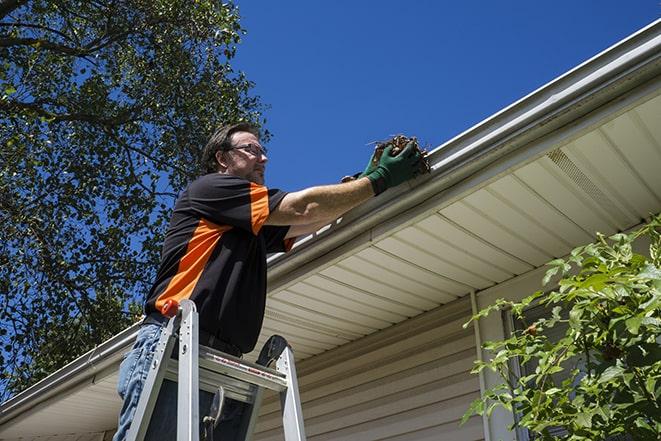 rain gutter being fixed by a professional repairman in Brookline